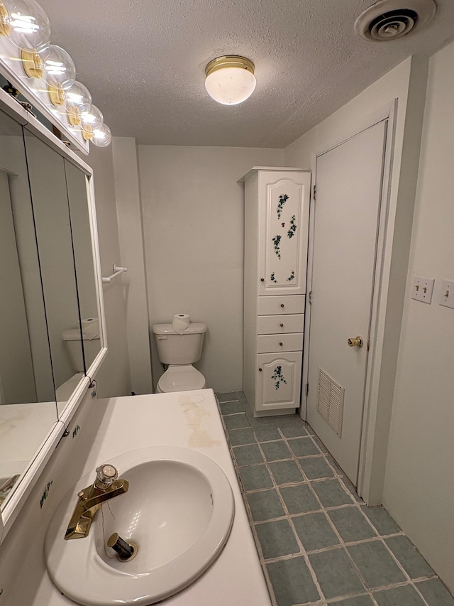 330 N Walnut St, Dillon, MT 59725 - bathroom featuring a textured ceiling, vanity, tile patterned floors, and toilet