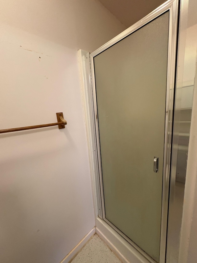 330 N Walnut St, Dillon, MT 59725 - bathroom featuring a stall shower, baseboards, and speckled floor