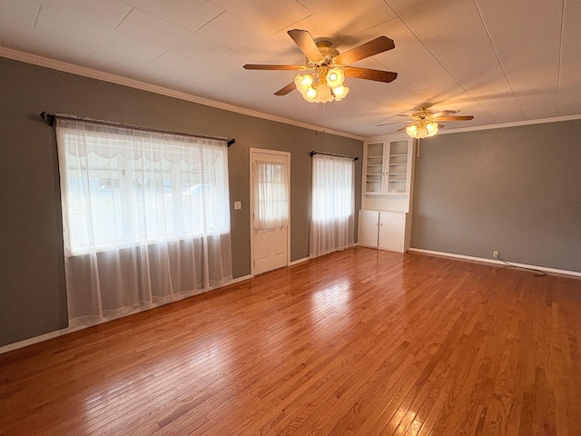 330 N Walnut St, Dillon, MT 59725 - empty room featuring ceiling fan, plenty of natural light, wood finished floors, ornamental molding, and built in features