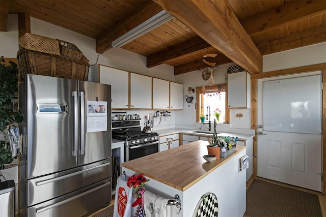 2879 Soft Rock Rd, Corvallis, MT 59828 - kitchen featuring stainless steel appliances, wooden ceiling with exposed beams, butcher block countertops, white cabinetry, and a sink