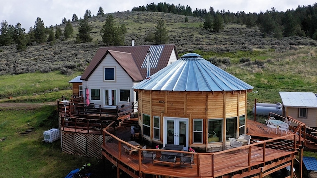 2879 Soft Rock Rd, Corvallis, MT 59828 - rear view of property featuring french doors, a wooden deck, metal roof, and a wooded view