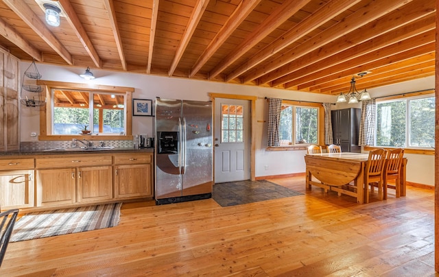 155 Seville Ln, Coram, MT 59913 - kitchen featuring stainless steel fridge with ice dispenser, healthy amount of natural light, baseboards, and wood ceiling with exposed beams