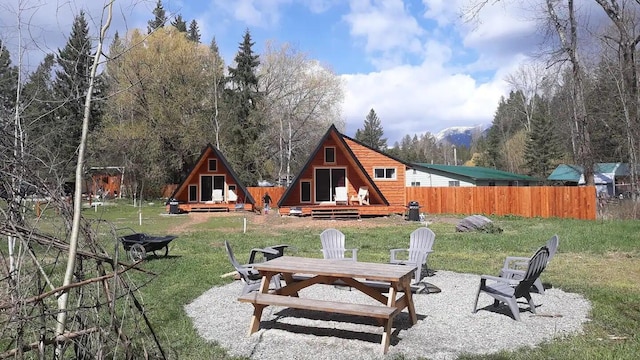 155 Seville Ln, Coram, MT 59913 - rear view of house featuring an outdoor fire pit and a wooden deck
