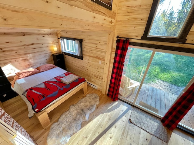 155 Seville Ln, Coram, MT 59913 - bedroom featuring wooden walls, hardwood / wood-style floors, and access to exterior