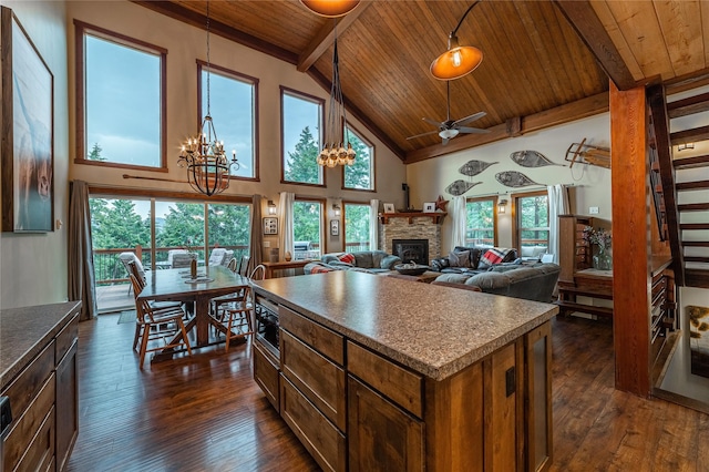 277 Ridge Loop Rd, Rexford, MT 59930 - kitchen with wood ceiling with exposed beams, dark wood-type flooring, a stone fireplace, a chandelier, and dark countertops