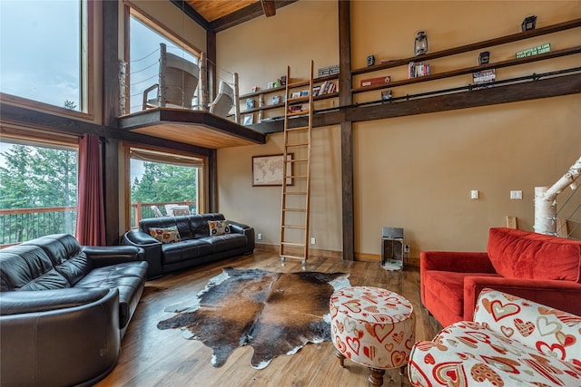 277 Ridge Loop Rd, Rexford, MT 59930 - living room featuring a towering ceiling, wood finished floors, beam ceiling, and baseboards