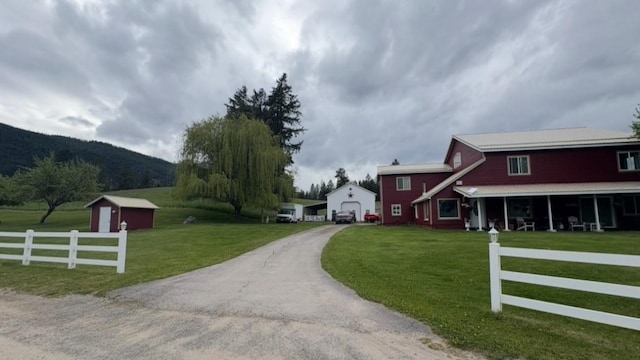 614 Johnson Ln, Superior, MT 59872 - view of front facade with driveway, a garage, a mountain view, and an outbuilding