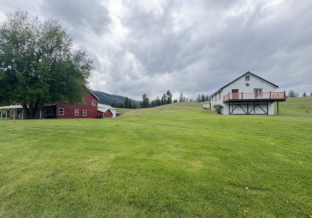614 Johnson Ln, Superior, MT 59872 - view of green lawn with a deck with mountain view and an outbuilding