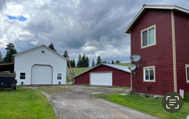 614 Johnson Ln, Superior, MT 59872 - view of side of home featuring a detached garage, an outdoor structure, and a yard