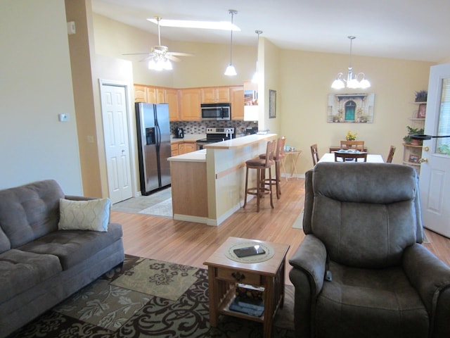 2220 Alpine Dr, Helena, MT 59601 - living area with lofted ceiling, light wood-style flooring, ceiling fan, a chandelier, and baseboards