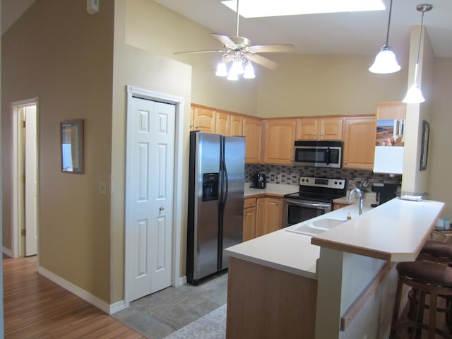 2220 Alpine Dr, Helena, MT 59601 - kitchen featuring appliances with stainless steel finishes, a peninsula, decorative backsplash, a ceiling fan, and light brown cabinets