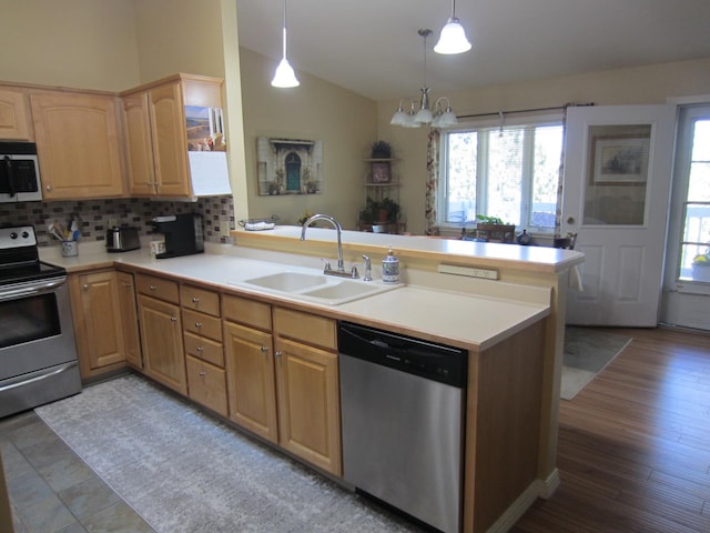 2220 Alpine Dr, Helena, MT 59601 - kitchen featuring stainless steel appliances, a sink, a peninsula, vaulted ceiling, and decorative backsplash