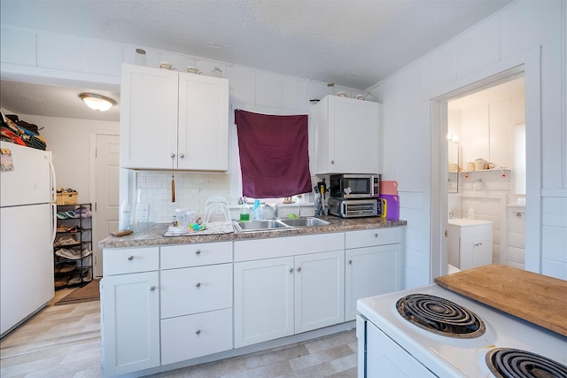 705 3rd St W, Polson, MT 59860 - kitchen featuring white appliances, a sink, white cabinets, light floors, and light countertops