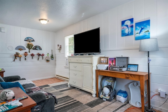 705 3rd St W, Polson, MT 59860 - living area featuring light wood-type flooring, a baseboard heating unit, and a textured ceiling