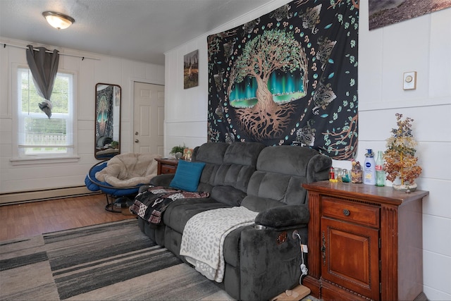 705 3rd St W, Polson, MT 59860 - living area featuring a baseboard radiator, wood finished floors, and a decorative wall