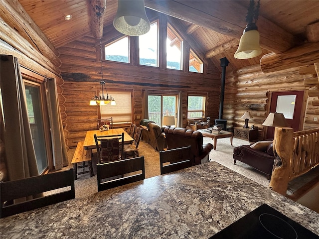 3966 Main Boulder Rd, Big Timber, MT 59011 - living room featuring a wood stove, log walls, wood ceiling with exposed beams, high vaulted ceiling, and carpet floors