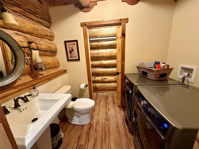 3966 Main Boulder Rd, Big Timber, MT 59011 - bathroom featuring rustic walls, independent washer and dryer, wood finished floors, toilet, and a sink