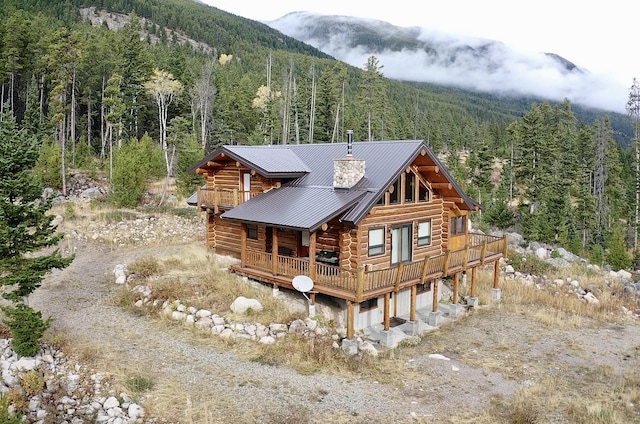 3966 Main Boulder Rd, Big Timber, MT 59011 - rear view of property with a wooded view, log siding, dirt driveway, metal roof, and a deck with mountain view