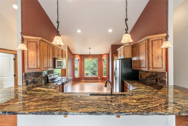 10 Canyon Breeze Ct, Stevensville, MT 59870 - kitchen featuring appliances with stainless steel finishes, a sink, a peninsula, backsplash, and high vaulted ceiling