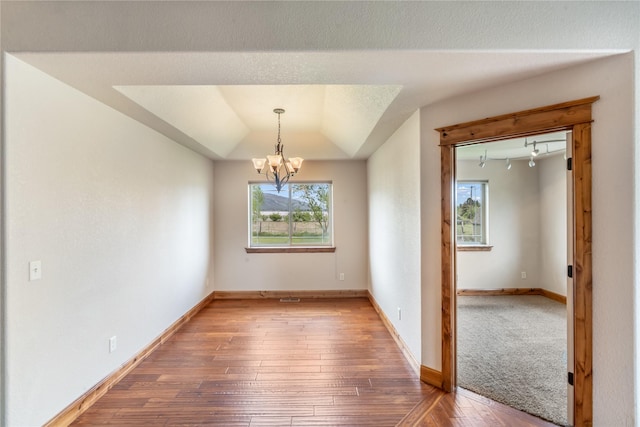 10 Canyon Breeze Ct, Stevensville, MT 59870 - empty room featuring hardwood / wood-style flooring, a chandelier, baseboards, and vaulted ceiling