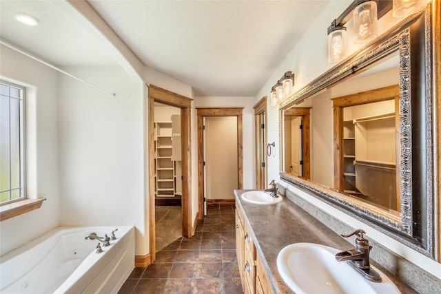 10 Canyon Breeze Ct, Stevensville, MT 59870 - bathroom featuring a jetted tub, double vanity, baseboards, and a walk in closet