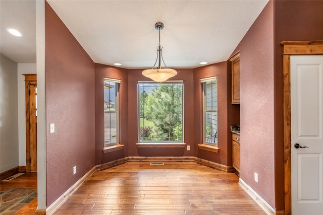 10 Canyon Breeze Ct, Stevensville, MT 59870 - unfurnished dining area featuring light wood-style flooring, a textured wall, and baseboards