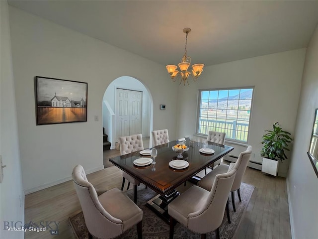 4160 Geneva Ln, Butte, MT 59701 - dining area with arched walkways, a chandelier, light wood-style flooring, and stairway