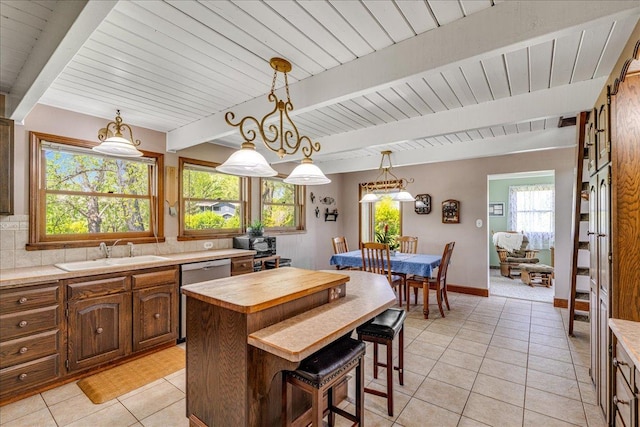 70 Dune Hill Ln, Great Falls, MT 59404 - kitchen featuring a sink, light tile patterned flooring, dishwasher, decorative backsplash, and a kitchen island
