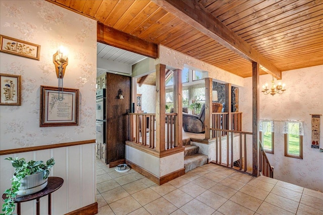 70 Dune Hill Ln, Great Falls, MT 59404 - hall featuring plenty of natural light, wood ceiling with exposed beams, wallpapered walls, light tile patterned floors, and a chandelier