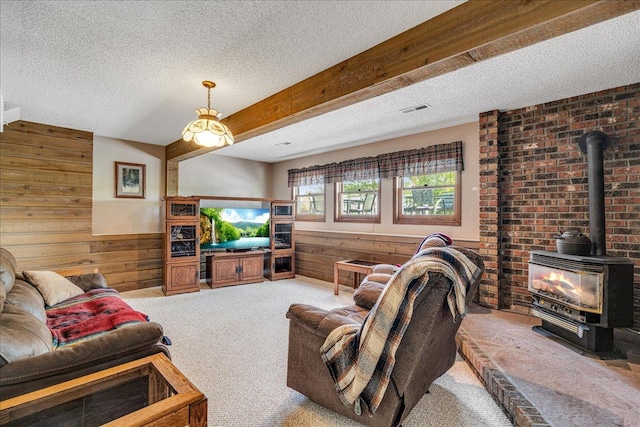 70 Dune Hill Ln, Great Falls, MT 59404 - carpeted living area featuring a textured ceiling, wood walls, a wood stove, and a wainscoted wall