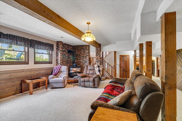 70 Dune Hill Ln, Great Falls, MT 59404 - carpeted living area with a wood stove, a textured ceiling, stairs, beamed ceiling, and wood walls