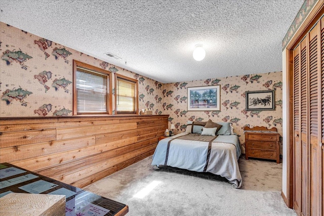 70 Dune Hill Ln, Great Falls, MT 59404 - carpeted bedroom with wallpapered walls, a textured ceiling, and a closet