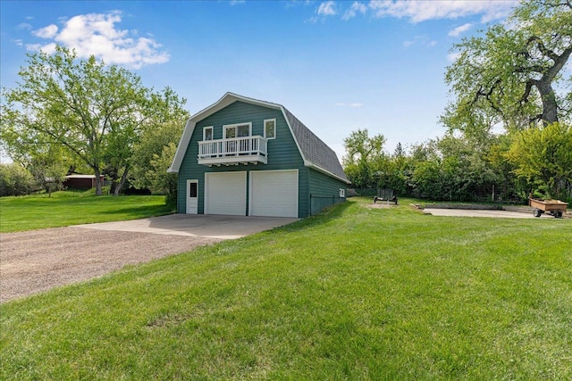 70 Dune Hill Ln, Great Falls, MT 59404 - view of property exterior with a gambrel roof, a balcony, driveway, a lawn, and a garage