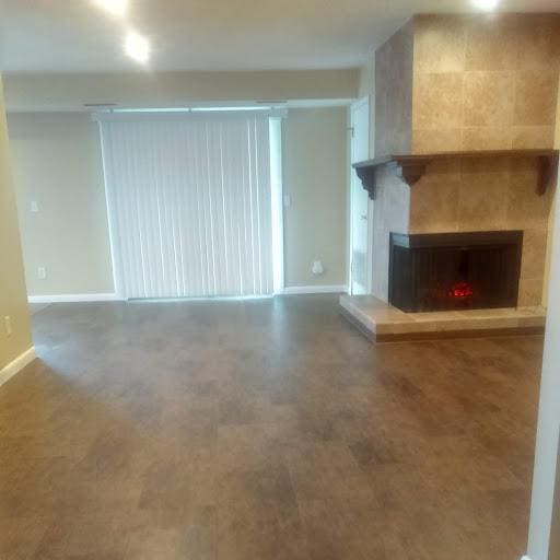 1380 Easy St, Billings, MT 59105 - unfurnished living room featuring baseboards and a tiled fireplace