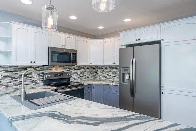 1605 Lund Ln, Polson, MT 59860 - kitchen featuring stainless steel appliances, white cabinets, open shelves, light stone counters, and hanging light fixtures