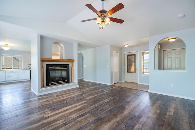 1605 Lund Ln, Polson, MT 59860 - unfurnished living room with lofted ceiling, a ceiling fan, wood finished floors, a glass covered fireplace, and arched walkways