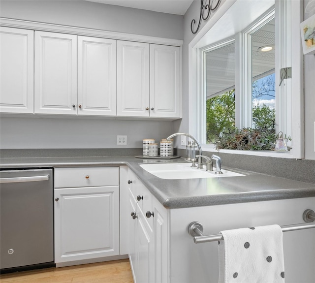 2030 Highland St, Helena, MT 59601 - kitchen featuring stainless steel dishwasher, a sink, white cabinets, and light wood-style flooring