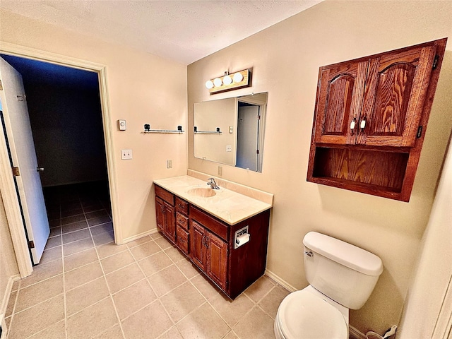 310 W Armitage St, Ennis, MT 59729 - bathroom featuring vanity, tile patterned floors, toilet, baseboards, and a textured ceiling