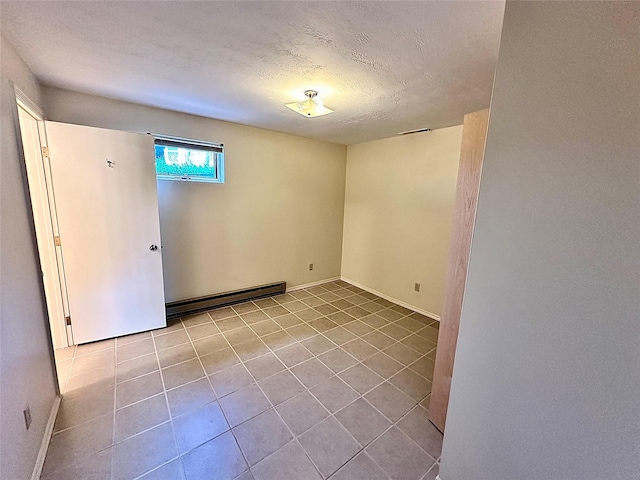 310 W Armitage St, Ennis, MT 59729 - tiled spare room featuring baseboard heating, a textured ceiling, and baseboards