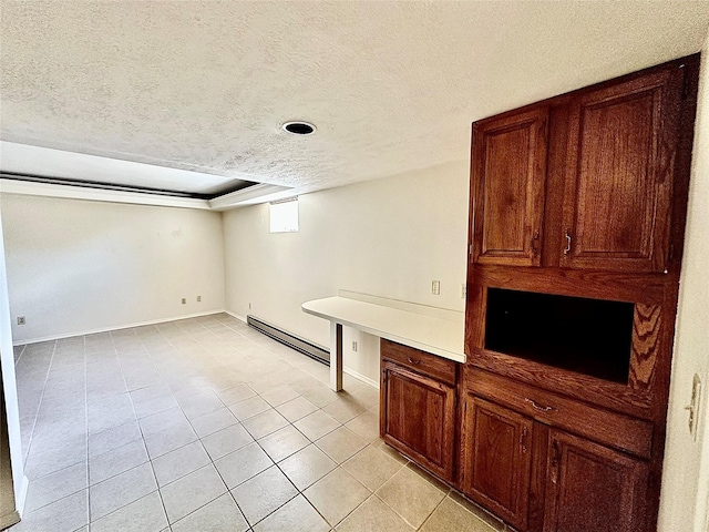 310 W Armitage St, Ennis, MT 59729 - basement featuring baseboard heating, a textured ceiling, light tile patterned floors, and baseboards