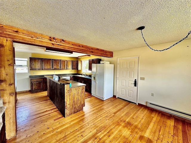 310 W Armitage St, Ennis, MT 59729 - kitchen with white refrigerator with ice dispenser, a textured ceiling, a center island, light wood-style flooring, and healthy amount of natural light