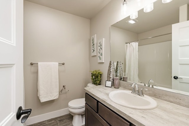 249 Stirling Loop, East Helena, MT 59635 - full bathroom featuring toilet, wood finished floors, baseboards, vanity, and a shower with shower curtain