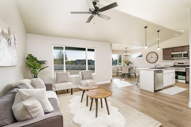 249 Stirling Loop, East Helena, MT 59635 - living area featuring lofted ceiling, light wood-style floors, a ceiling fan, baseboards, and a chandelier