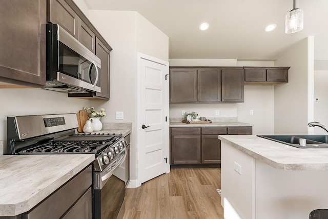 249 Stirling Loop, East Helena, MT 59635 - kitchen featuring stainless steel appliances, a sink, light wood finished floors, dark brown cabinets, and light countertops