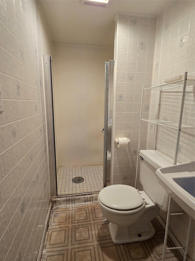 3421 4th Ave N, Great Falls, MT 59401 - full bathroom featuring tile walls, toilet, a stall shower, and tile patterned flooring