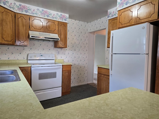 3421 4th Ave N, Great Falls, MT 59401 - kitchen with white appliances, under cabinet range hood, light countertops, wallpapered walls, and brown cabinets