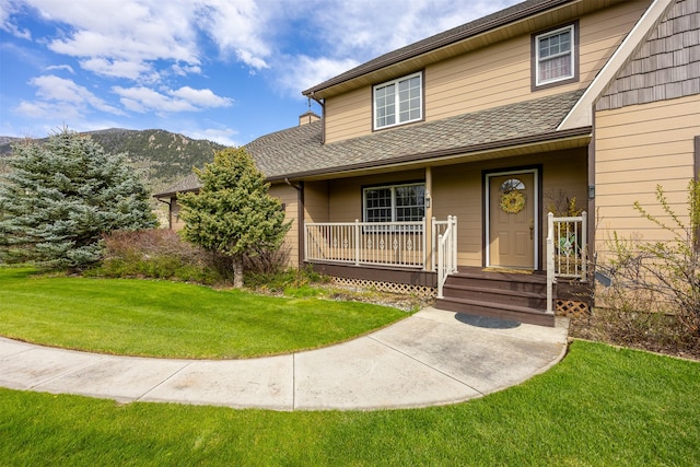 150 Painted Mdws, Butte, MT 59701 - view of front of property with covered porch, a front yard, a mountain view, and a shingled roof