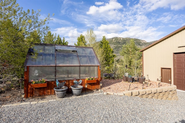 150 Painted Mdws, Butte, MT 59701 - view of patio / terrace with a greenhouse, an outbuilding, and a mountain view