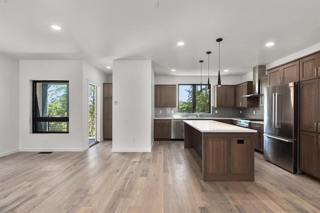 713 W 2nd St W, Whitefish, MT 59937 - kitchen with appliances with stainless steel finishes, recessed lighting, wall chimney exhaust hood, a center island, and light countertops