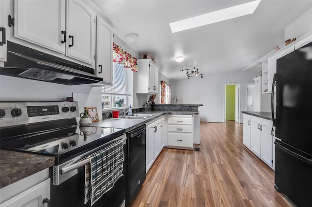 3805 7th St NE Unit 107, Great Falls, MT 59404 - kitchen featuring black appliances, under cabinet range hood, a skylight, a sink, and white cabinetry
